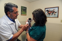 Dr. Richard Avery, 902nd Force Support Squadron veterinarian, and Margaret Williamson, 902nd FSS veterinary technician, examine a chihuahua puppy May 21 at the Joint Base San Antonio-Randolph veterinary clinic. (U.S. Air Force photo by Rich McFadden) 