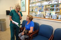 Donna Bothe, 902nd Force Support Squadron veterinary clinic office manager, reviews pet records with Brigitta Manna May 21 at the Joint Base San Antonio-Randolph veterinary clinic .  (U.S. Air Force photo by Rich McFadden) 