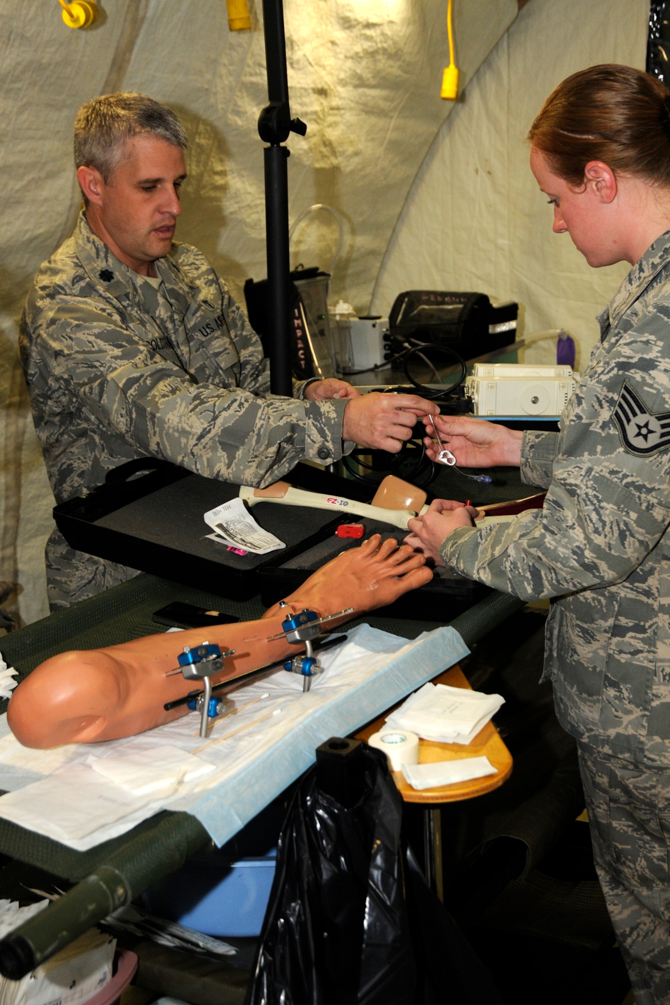 Lt. Col. Dr. Robert Goldtrap, 188th Medical Group, Arkansas Air National Guard, demonstrates a procedure to Staff Sgt. Jamie McClelland, 127th Medical Group, Michigan Air National Guard, during a training exercise at the Alpena Combat Readiness Training Center, Mich., May 23, 2012. The exercise brought together Airmen from eight medical groups from seven states. (U.S. Air Force photo by TSgt. David Kujawa)