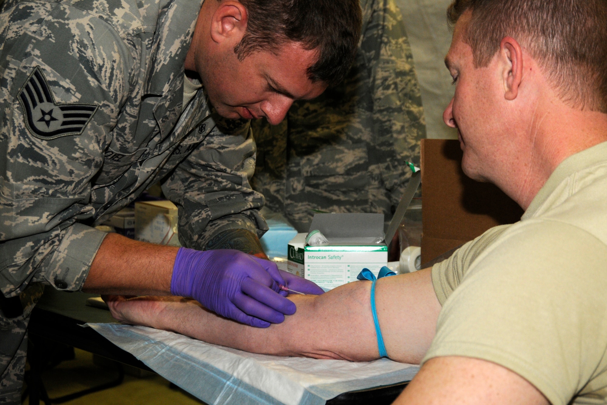 Staff Sgt. Chris Doyel, 188th Medical Group, Arkansas Air National Guard, inserts an IV line into Chaplain (Major) Herb Hodde, 188th Fighter Wing, during a training exercise at the Alpena Combat Readiness Training Center, Mich., May 23, 2012. The exercise brought together Airmen from eight medical groups from seven states. (U.S. Air Force photo by TSgt. David Kujawa)