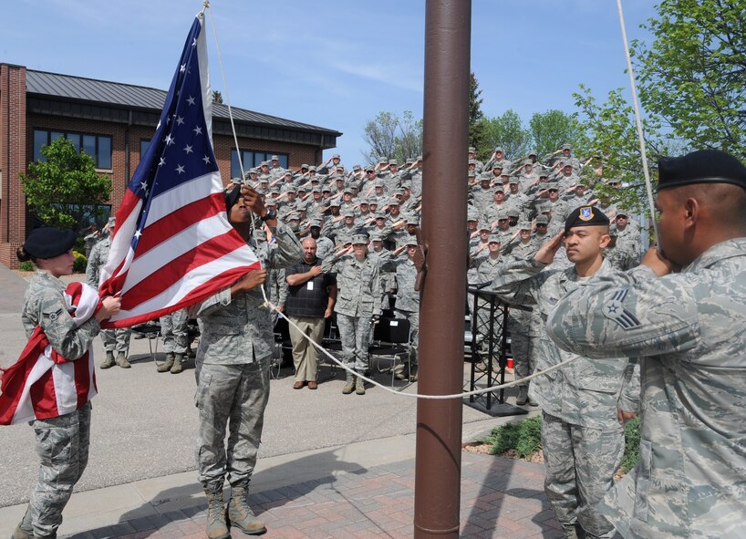 Members of the 319th Security Forces Squadron pay respect to the American flag during retreat ceremony May 17, 2012, on Grand Forks Air Force Base, N.D., for National Police Week. (U.S. Air Force photo by Senior Airman Amber Bennett)