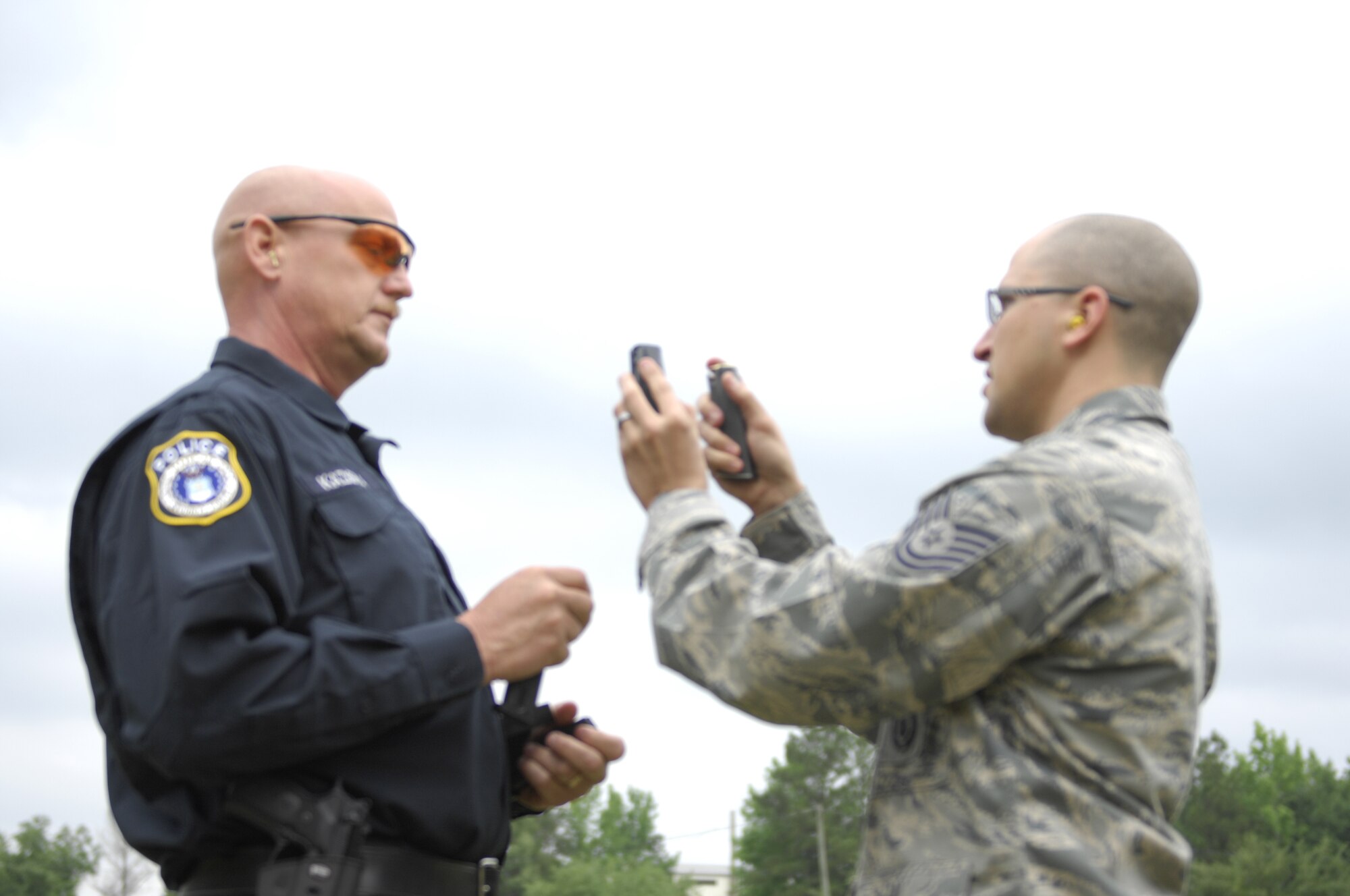 SHAW AIR FORCE BASE, S.C. – U.S. Air Force Tech. Sgt. Gary A. Chapin, 20th Security Forces Squadron combat arms instructor, compares magazines and socializes with Eric E. Kaziska, a civilian police officer with the 20th Security Forces Squadron, at a pistol tournament at the the Sumter Police Department firing range on May 18, 2012. The tournament was one of the events during Police Week and gave Airmen and local police officers an opportunity to interact outside of work with a friendly competition together. Police Week is a week dedicated to recognizing the sacrifices police officers give to protect the public and make the communities safer. (U.S. Air Force photo by Airman 1st Class Krystal M. Jeffers/ Release)