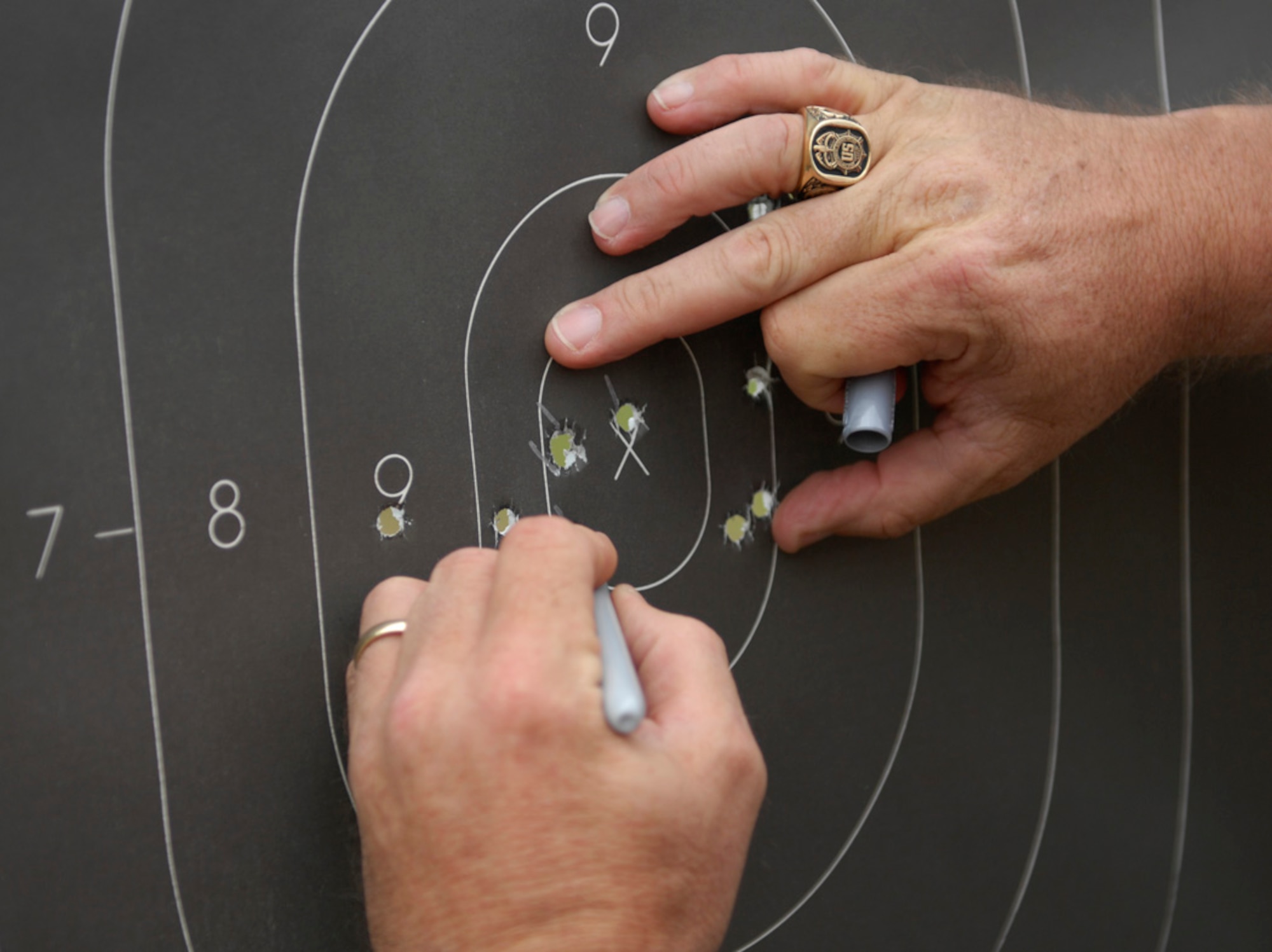 SHAW AIR FORCE BASE, S.C. – Police Lt. Feddie L. Bradshaw, Sumter Police Department narcotics vice unit and volunteer firearms instructor, scores target sheets for the pistol tournament that was part of Police Week at the Sumter Police Department, S.C., firing range on May 18, 2012. National Police Week is a week dedicated to police officers who make daily sacrifices to make the neighborhoods safer. (U.S. Air Force photo by Airman 1st Class Krystal M. Jeffers/ Release)