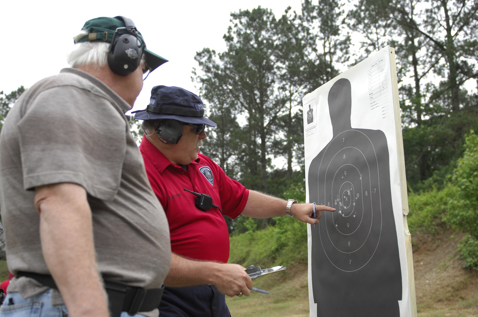 SHAW AIR FORCE BASE, S.C. –Police Lt. Feddie L. Bradshaw, Sumter Police Department narcotics vice unit and volunteer firearms instructor, scores the shooting of Jim R. Reading’s, who has been a state constable for 20 years, during a pistol tournament at the Sumter Police Department, S.C., firing range on May 18, 2012. 20th Security Forces Squadron Airmen and local and state police officers gathered  to build camaraderie during Police Week. National Police Week recognizes police officers and the hard work they perform daily for their communities. (U.S. Air Force photo by Airman 1st Class Krystal M. Jeffers/ Release)