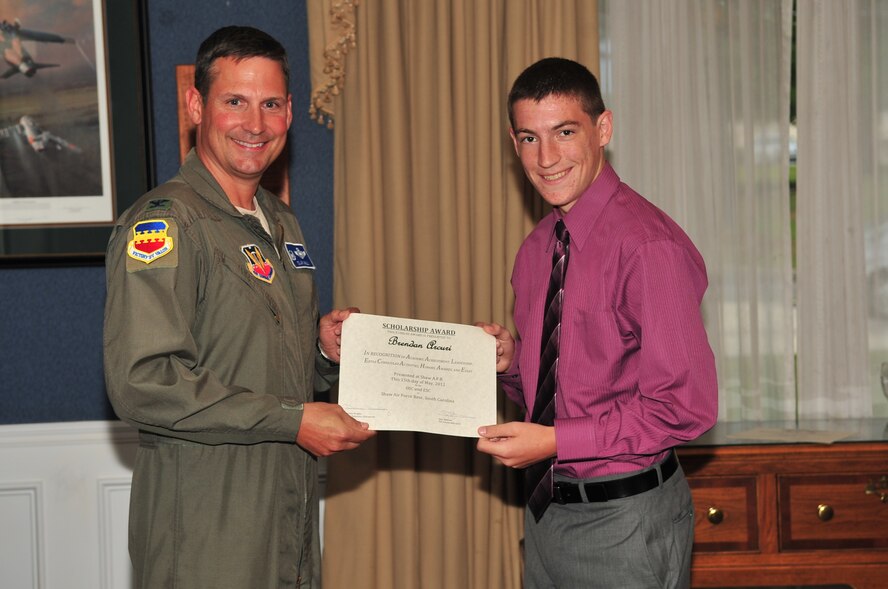 U.S. Air Force Col. Clay Hall, 20th Fighter Wing commander, poses for a photo with a scholarship award winner during the 2012 officer spouses' club and enlisted spouses' club dinner, Shaw Air Force Base, S.C., May 15, 2012. (U.S. Air Force photo by Airman 1st Class Ashley L. Gardner/ Released)