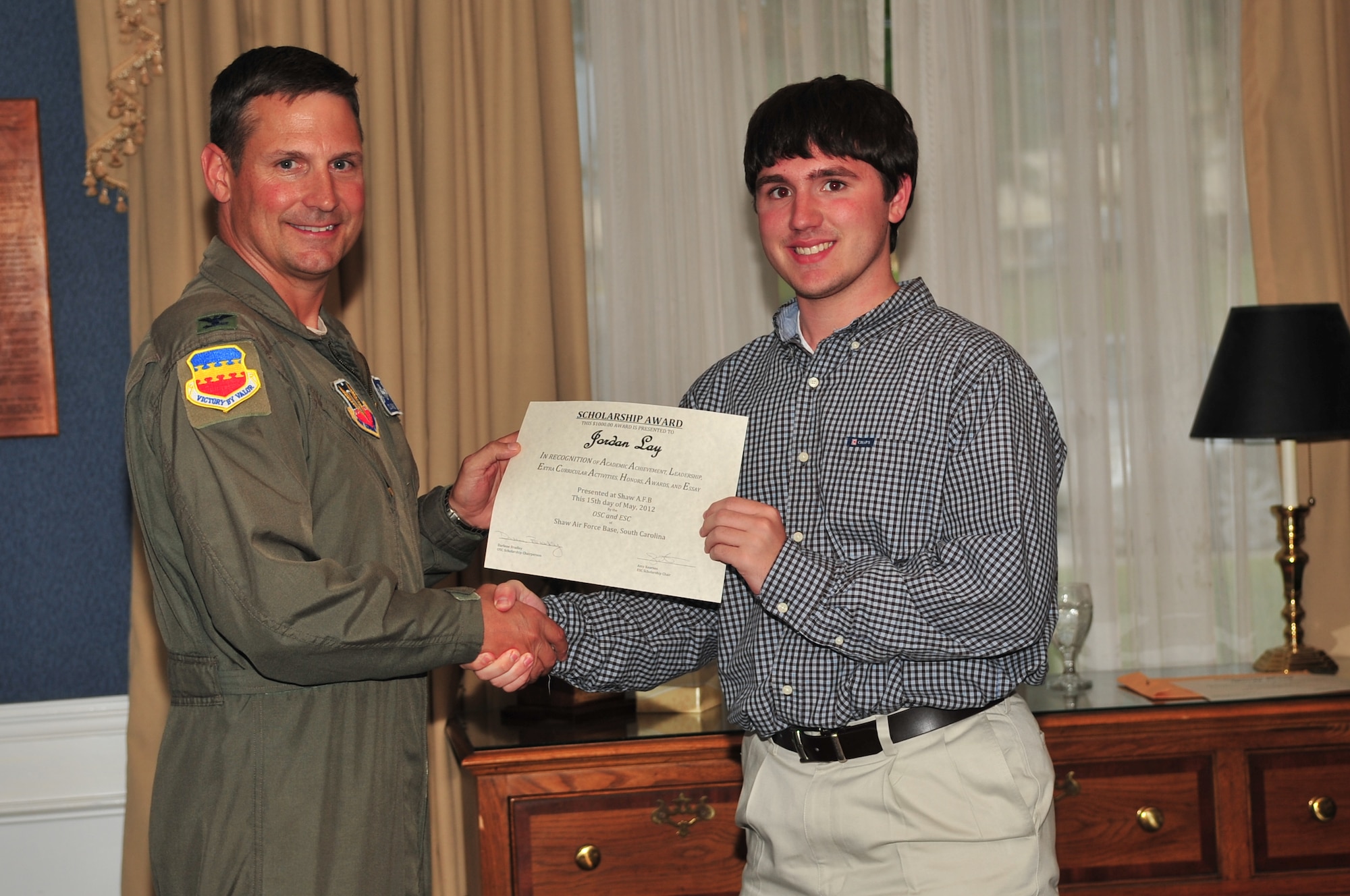 U.S. Air Force Col. Clay Hall, 20th Fighter Wing commander, poses for a photo with a scholarship award winner during the 2012 officer spouses' club and enlisted spouses' club dinner, Shaw Air Force Base, S.C., May 15, 2012. (U.S. Air Force photo by Airman 1st Class Ashley L. Gardner/ Released)