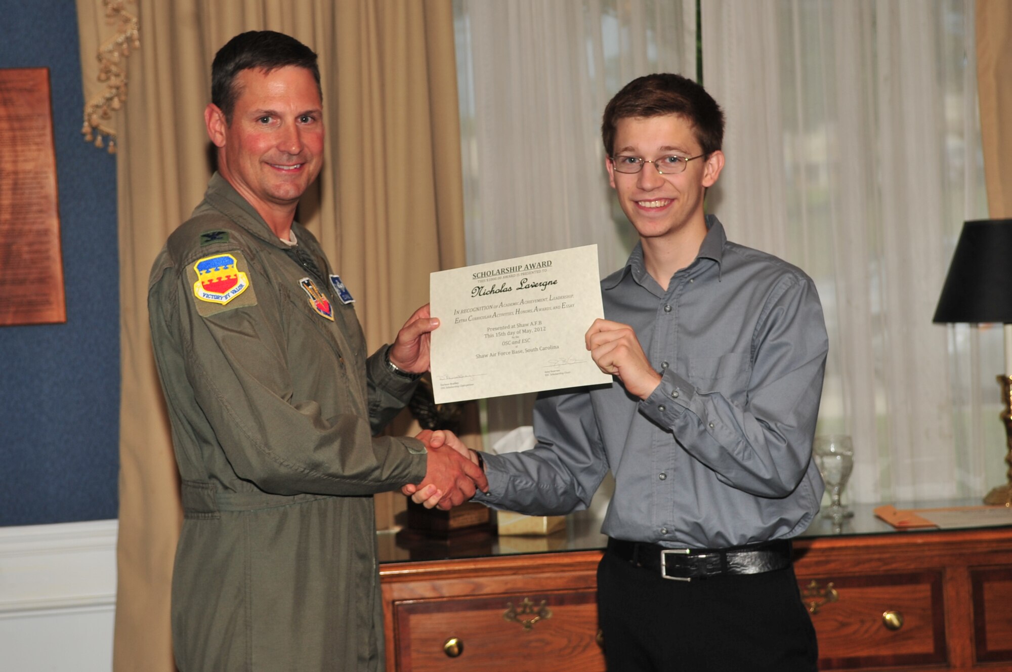 U.S. Air Force Col. Clay Hall, 20th Fighter Wing commander, poses for a photo with a scholarship award winner during the 2012 officer spouses' club and enlisted spouses' club dinner, Shaw Air Force Base, S.C., May 15, 2012. (U.S. Air Force photo by Airman 1st Class Ashley L. Gardner/ Released)