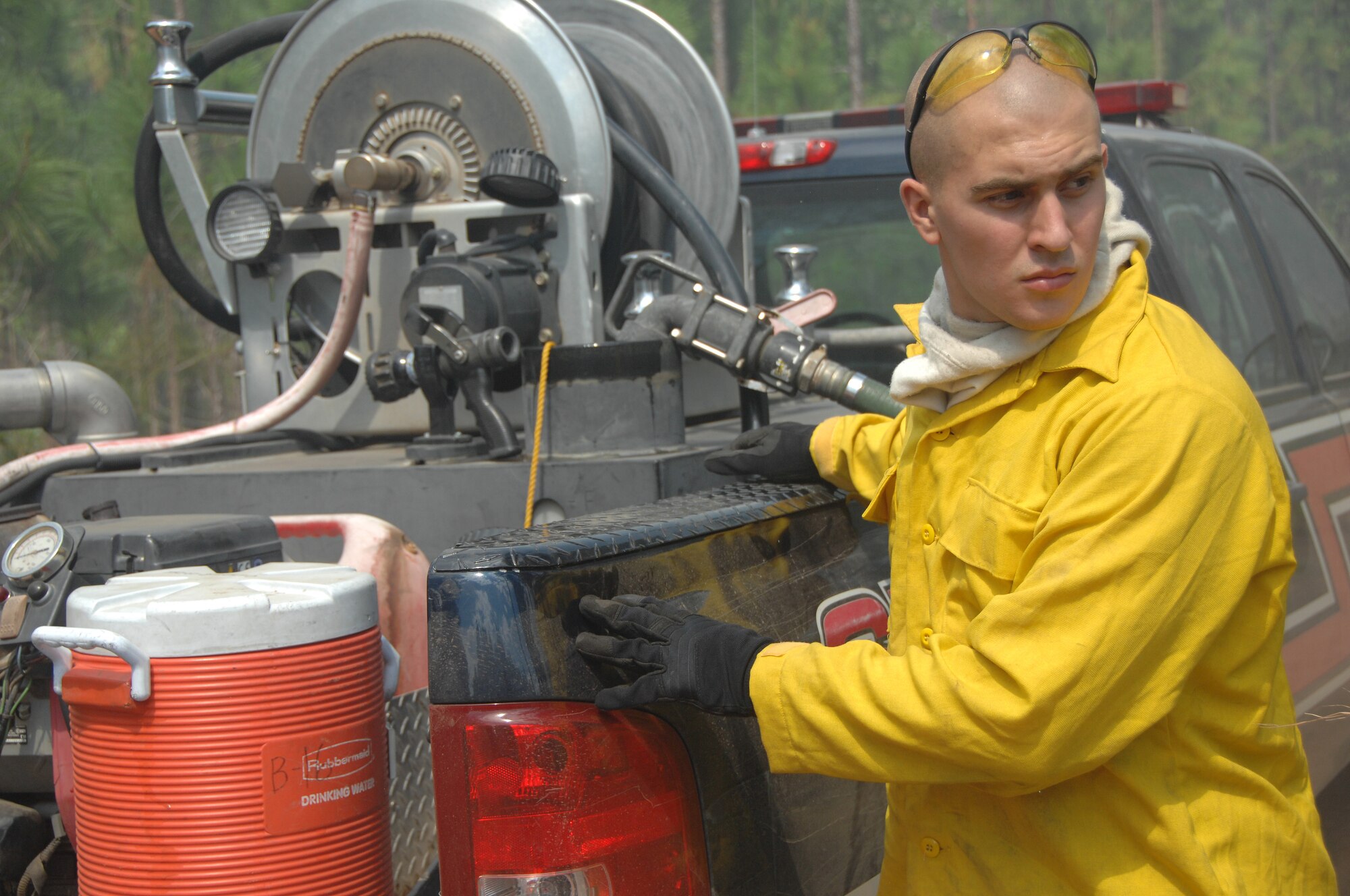 U.S. Air Force Airman Clayton Angeloff, 20th Civil Engineer Squadron firefighter, prepares to refill his water tank to attack a fire at Poinsett Electronic Combat Range, S.C., May 21, 2012. Shaw’s firefighters responded quickly to a 150-acre blaze at the Poinsett Range training site. (U.S. Air Force photo by Airman 1st Class Blake Hubbard/Released)