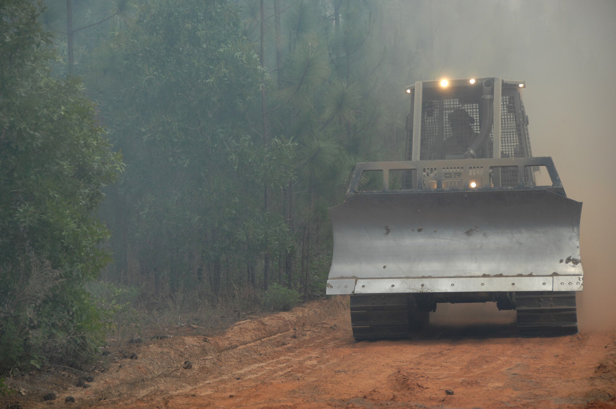 The South Carolina Forestry Department constructs trenches to manipulate the direction and dissemination of a fire throughout the wooded area at Poinsett Electronic Combat Range, S.C., May 21, 2012. Shaw’s firefighters responded quickly to a 150-acre blaze at the Poinsett Range training site. (U.S. Air Force photo by Airman 1st Class Blake Hubbard/Released)