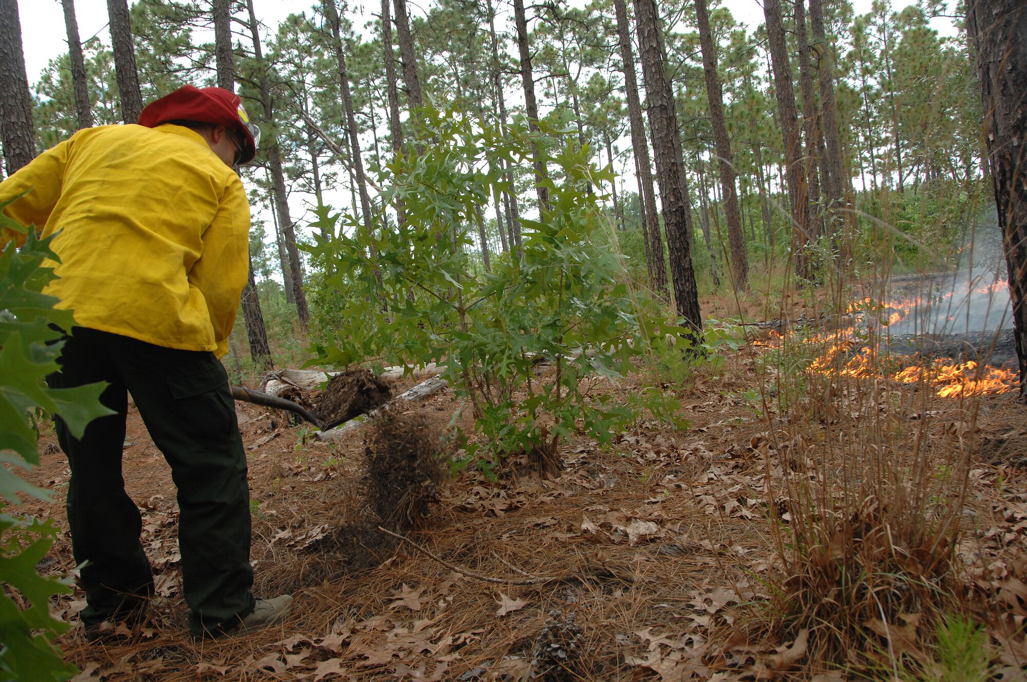 U.S. Air Force Staff Sgt. Chastin Warner, 20th Civil Engineer Squadron firefighter, shovels dirt onto a fire to contain it from spreading at Poinsett Electronic Combat Range, S.C., May 21, 2012. Shaw’s firefighters responded quickly to a 150-acre blaze at the Poinsett Range training site. (U.S. Air Force photo by Airman 1st Class Blake Hubbard/Released)
