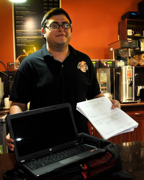 Gabriel Rodrigues, Blazin Beans employee, displays a new laptop available for free use at the base coffee shop, May 22. The service is available to all Department of Defense identification card holders. Participants need only to show their identification card, sign a hand receipt, and a laptop will be issued. (U.S. Air Force photo by Ross Tweten) 