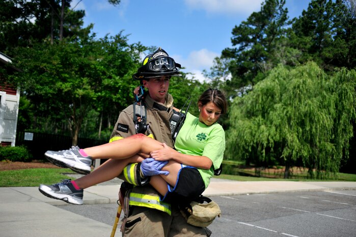 Staff Sgt. Sam Siewert, a volunteer engineer with the Ashley River Fire Department and a firefighter on Joint Base Charleston carries a burn victim role player during a mass causality exercise May 15, 2012 at the Amenity Center in The Farm at Wescott Plantation.  Department of Health and Environmental Control District 7, in conjunction with Joint Base Charleston members, local emergency medical services, fire departments, law enforcement, coroners and all Charleston area hospitals conducted the live, mass causality incident readiness exercise to test first responder abilities and processes.   (U.S. Air Force Photo/Senior Airman Nicholas Pilch)