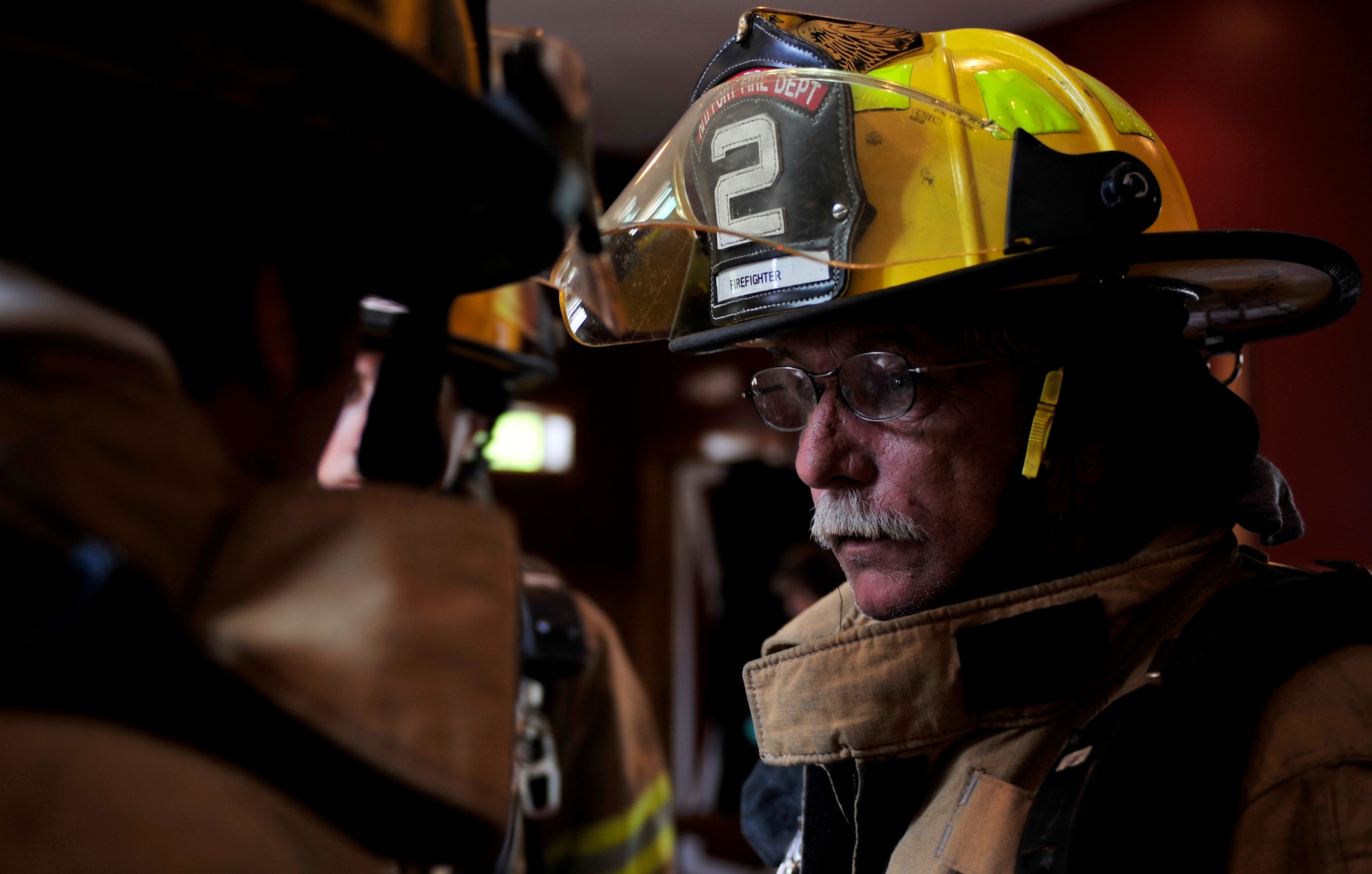 Joel Woods, a firefighter with the Old Fort Fire Department confers with fellow firefighters during a mass causality exercise May 15, 2012 at the Amenity Center in The Farm at Wescott Plantation.  Department of Health and Environmental Control  District 7, in conjunction with Joint Base Charleston members, local emergency medical services, fire departments, law enforcement, coroners and all Charleston area hospitals conducted the live, mass causality incident readiness exercise to test first responder abilities and processes.   (U.S. Air Force Photo/Senior Airman Nicholas Pilch) 