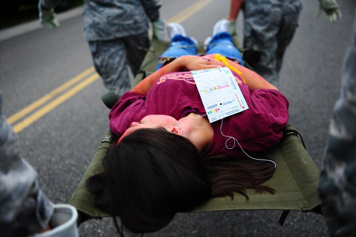 A burn victim role player is transported on a stretcher to the Joint Base Charleston Ambu-bus during a mass causality exercise May 15, 2012 at the Amenity Center in The Farm at Wescott Plantation. Department of Health and Environmental Control District 7, in conjunction with Joint Base Charleston members, local emergency medical services, fire departments, law enforcement, coroners and all Charleston area hospitals conducted the live, mass causality incident readiness exercise to test first responder abilities and processes.   (U.S. Air Force Photo/Airman 1st Class Jodi Martinez) 