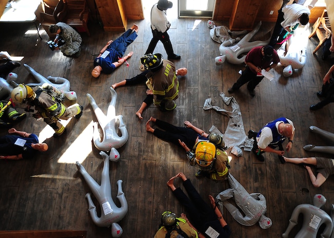 First responders check "injuries" of dummies and manikins after a simulated emergency May 15, 2012 at the Amenity Center in The Farm at Wescott Plantation. Department of Health and Environmental Control District 7, in conjunction with Joint Base Charleston members, local emergency medical services, fire departments, law enforcement, coroners and all Charleston area hospitals conducted the live, mass causality incident readiness exercise to test first responder abilities and processes. (U.S. Air Force Photo/Tech. Sgt. Tony Tolley) 