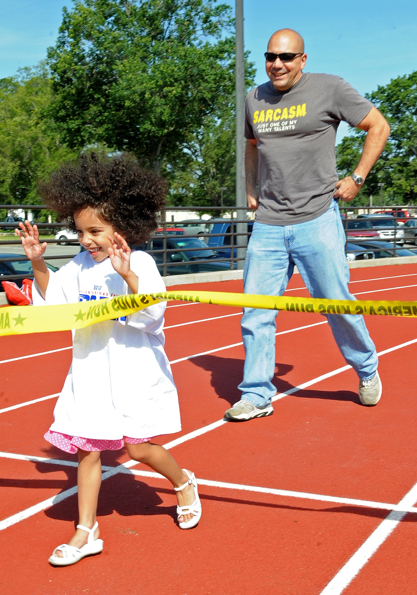 Madelyn Manfre, 5, crosses the finish line as her father, U.S. Air Force Tech. Sgt. Anthony Manfre, follows during a one-mile race on Seymour Johnson Air Force Base, N.C., May 19, 2012. Parents ran with their children during the America’s Armed Forces Kids Run event. Manfre is the 4th Fighter Wing command post training manager and hails from Kearny, N.J. Madelyn is a native of St. Louis. (U.S. Air Force photo/Airman 1st Class Aubrey Robinson/Released)