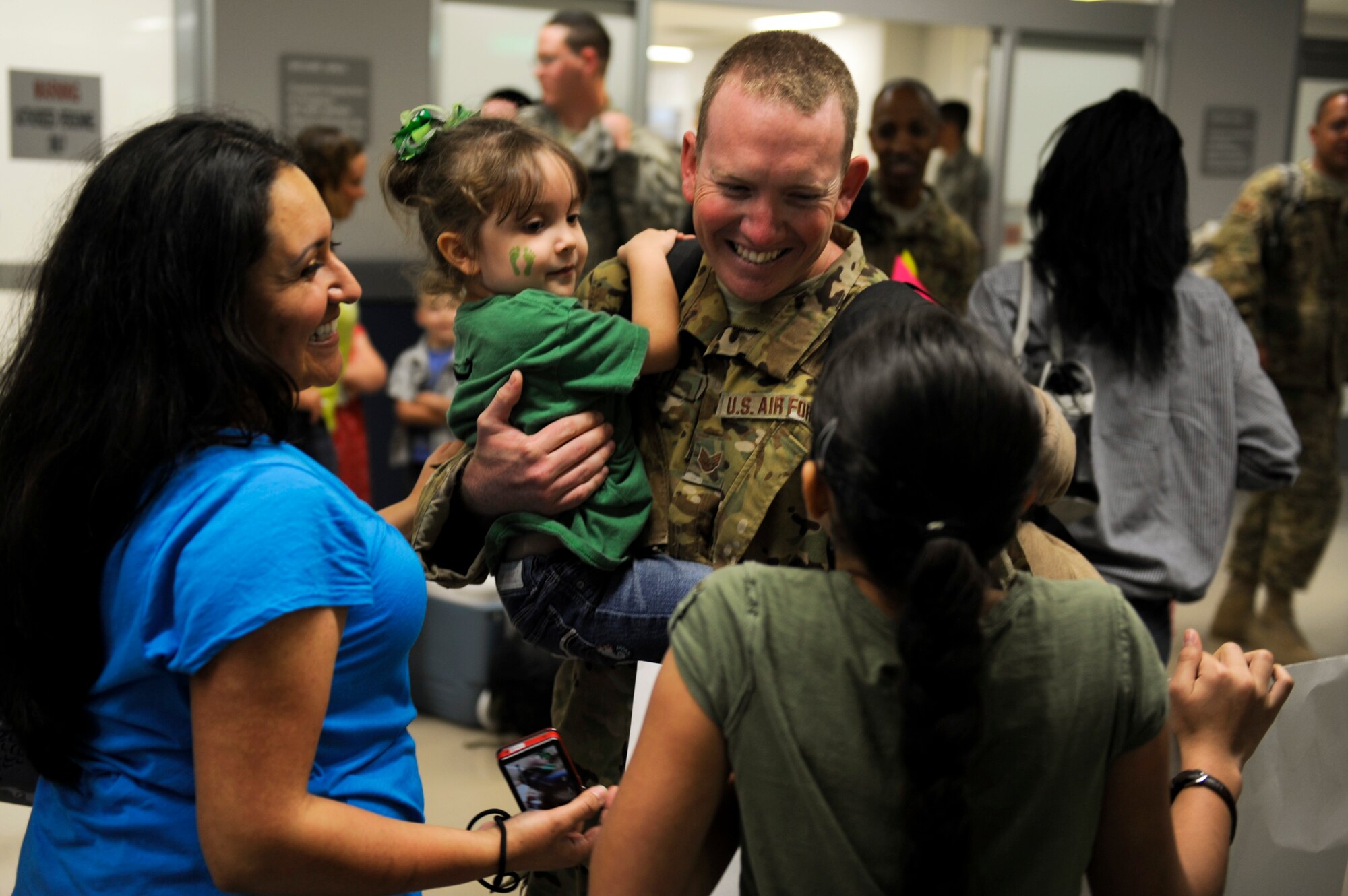 U.S. Air Force Staff Sgt. Mark Smith, 33rd Rescue Squadron flight engineer, greets his family during the 33rd RQS and 718th Aircraft Maintenance Squadron's homecoming at the Air Mobility Command terminal on Kadena Air Base, Japan, May 20, 2012. About 50 Airmen from the two squadrons were deployed to Afghanistan in January, 2012. (U.S. Air Force photo/Airman 1st Class Maeson L. Elleman)