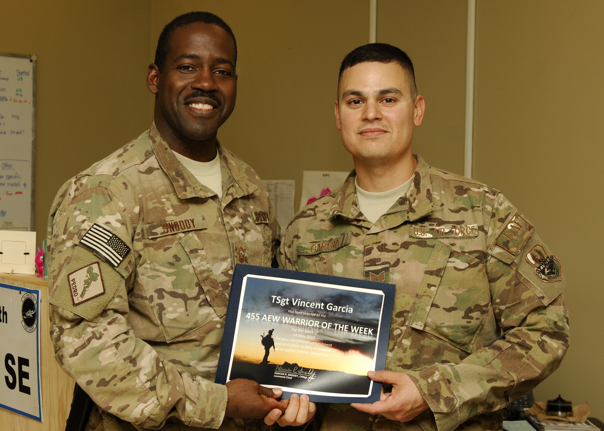 Chief Master Sgt.  Marcus Snoddy, 455th Air Expeditionary Wing command chief, presents Tech. Sgt. Vincent Garcia, 455 AEW Flight Safety noncommissioned officer in charge, the Warrior of the Week award for his outstanding performance as maintenance investigating member in charge of mishap reports for higher headquarters. Garcia developed and implemented the wing's flight safety program, to include operational risk management, trend analysis and spot inspections. His expert knowledge of safety regulations and local requirements are reflected in reduced mishaps rates across the entire airfield and on various combat airframes. (U.S. Air Force photo/Staff Sgt. Jeff Nevison)