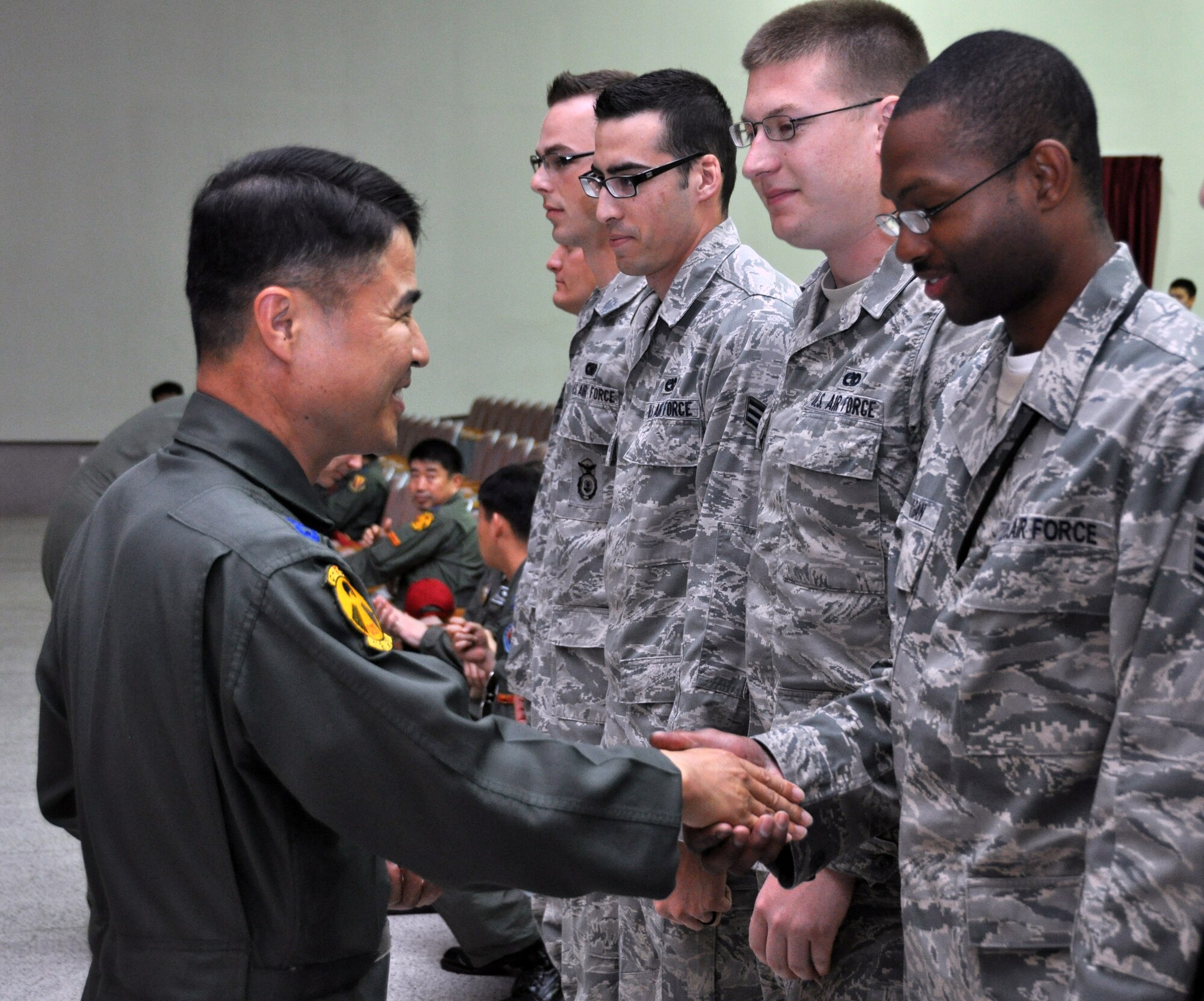 Col. Ahn Duk Sin, 29th Tactical Fighter Wing Group commander, coins Osan Air Base’s superior performers from exercise Max Thunder at Gwangju Air Base, Republic of Korea, May 18, 2012. The bilateral training involved approximately 60 U.S. Air Force and ROKAF aircraft, and roughly 450 Airmen from Osan, Kunsan, Daegu, Cheongju and Seosan air bases. (U.S. Air Force photo/Airman 1st Class Michael Battles)