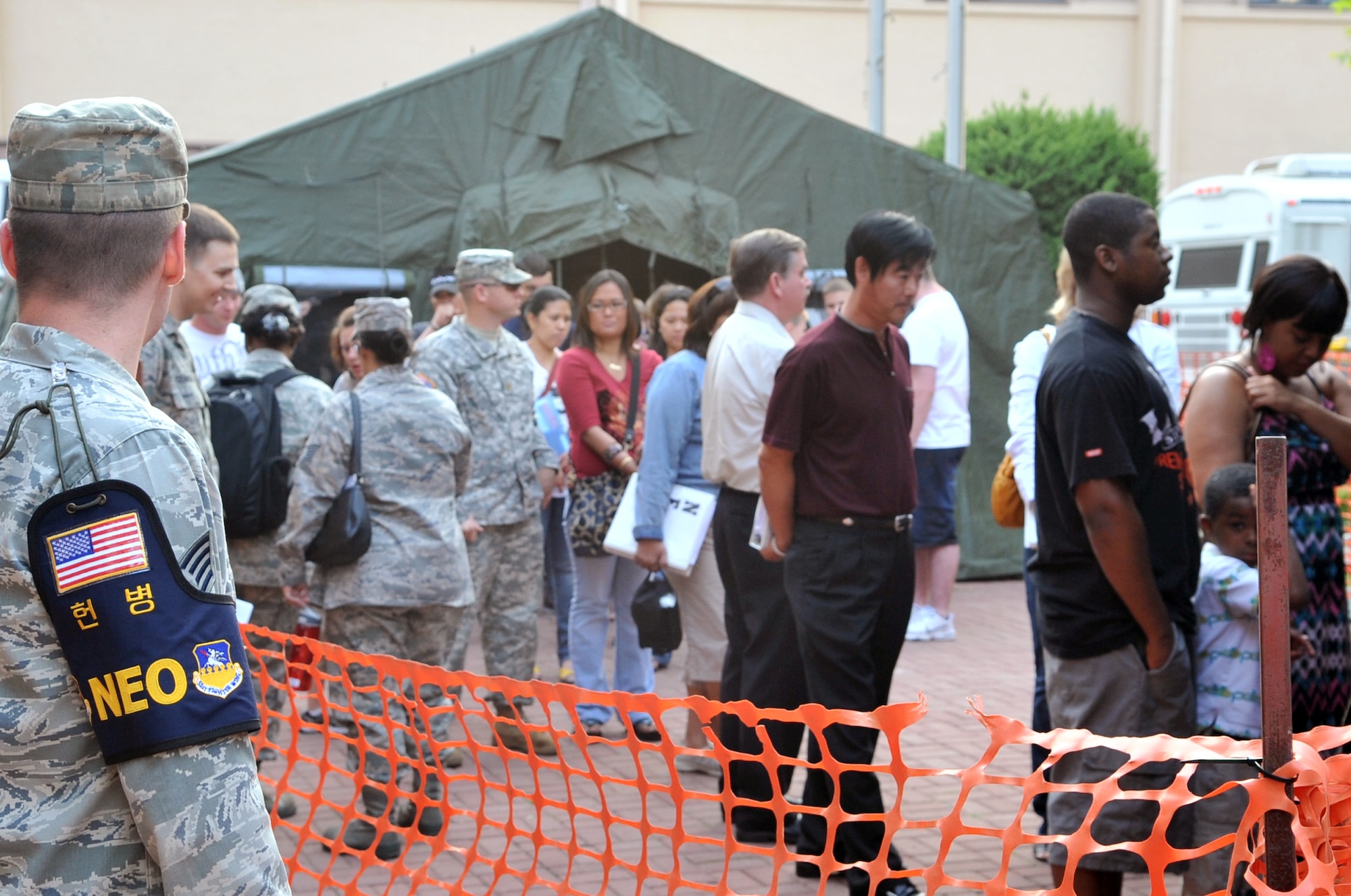 Military families process through an evacuation line at Osan High School during a Courageous Channel exercise, May 18, 2012, at Osan Air Base, Republic of Korea. Dependents, non-emergency essential civilians, and contractors processed the line, May 18-19, which was designed to train non-combatant evacuation operations-related mission essential tasks, increase readiness, and rehearse procedures to improve the ability of the command to evacuate families in Korea. Computer issues May 18, forced the NEO team to manually transfer data, which slowed processing times. However, the system was up and running smooth, the next day. (U.S. Air Force photo/Staff Sgt. Craig Cisek)