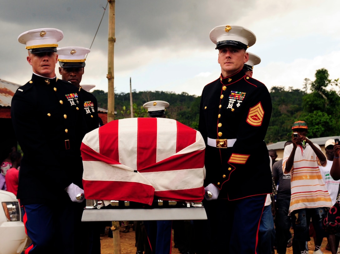 United States Marine Corps casket bearers navigate rocky terrain to deliver the remains of Lance Cpl. Abraham Tarwoe, of Providence, R.I., to the gravesite during a memorial service in Flehla, Liberia, May 17. Tarwoe, who was born in Liberia, died from wounds suffered in combat in Helmand province, Afghanistan April 12. At the time of his death, Tarwoe was deployed from 2nd Battalion, 9th Marine Regiment, Camp Lejeune, N.C. The casket bearers were all members of Operation ONWARD LIBERTY, a U.S. military mentor mission that is building capacity within the Armed Forces of Liberia. (U.S. Air Force photo by 1st Lt. Mark Lazane, Operation ONWARD LIBERTY Public Affairs) (Released)
