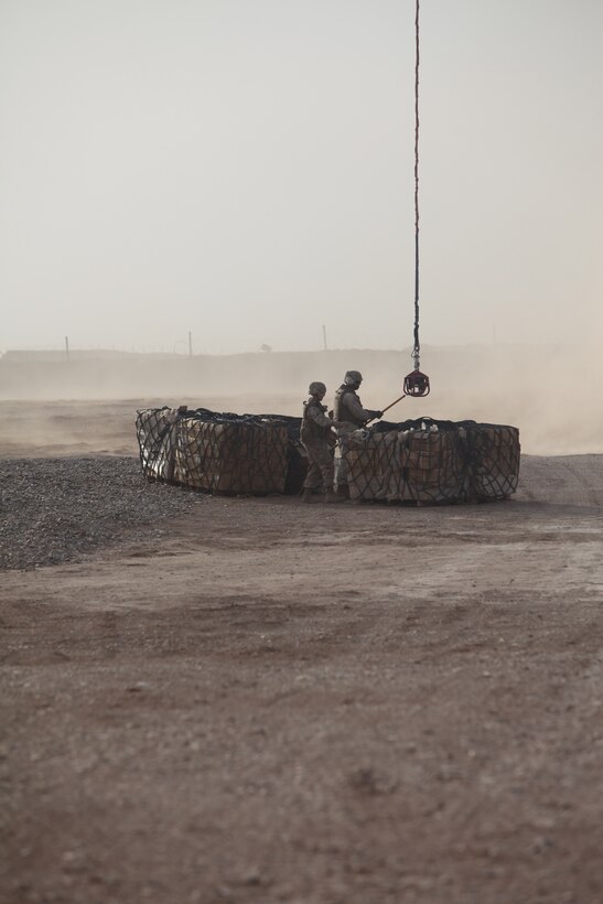 Lance Cpl. Mary Petric, (left), and Sgt. Malcolm Biddles, landing support specialists with Combat Logistics Battalion 5, 1st Marine Logistics Group (Forward), conduct a hot hook-up to an unmanned aerial vehicle at Camp Dwyer, Afghanistan, May 23. The landing support Marines were the first group ever to conduct a helicopter support team mission with the remote-controlled aircraft.