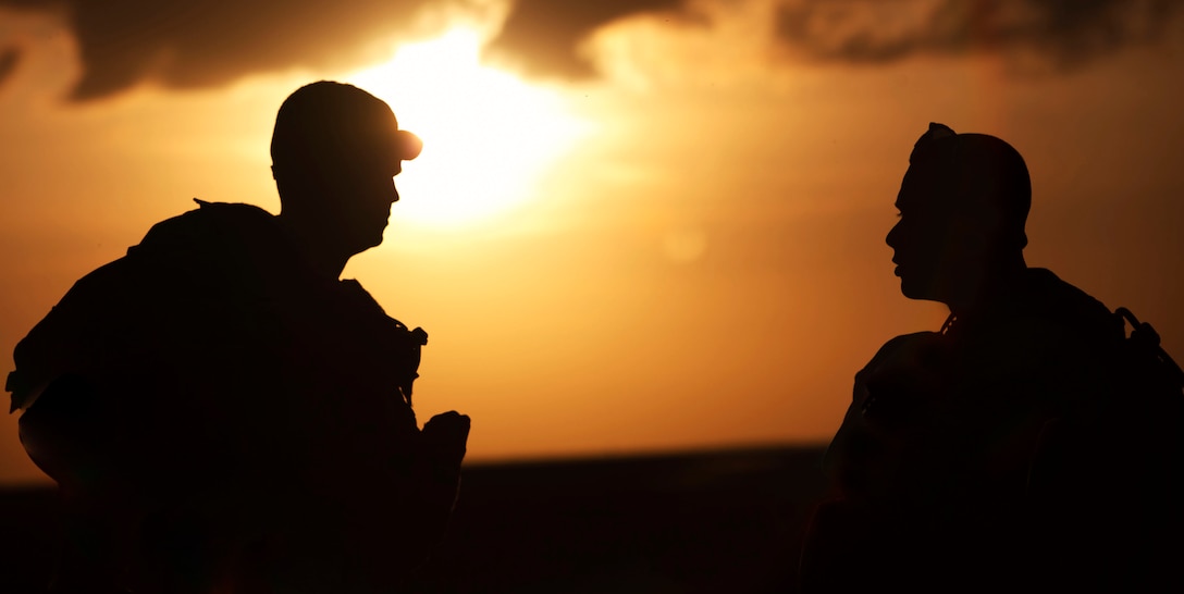 Lance Cpl. Adam N. Weinstein and Lance Cpl. Walter W. Banks, two radio operators with 4th Air Naval Gunfire Liaison Company, discuss an upcoming training exercise with each other aboard Piney Island, May 8. The team practiced radio communication with attack helicopter well into the night.