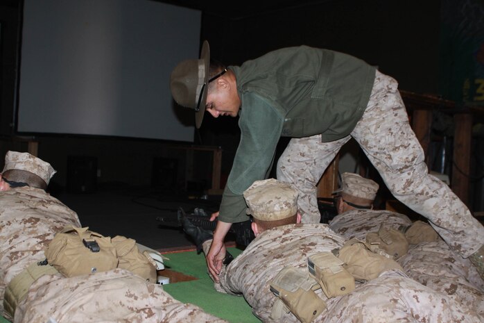 Cpl. Jamison Mersino, Primary Marksmanship Instructor, assists Company M recruits May 15 aboard Edson Range, Weapons and Field Training Battalion, Marine Corps Base Camp Pendelton. Co. M was taught the basic fundamentals of Marine Corps marksmenship. They were able to practice these fundamentals in the Indoor Simulated Marksmanship Trainer. This gave them a chance to see how they shoot before using a live service rifle.