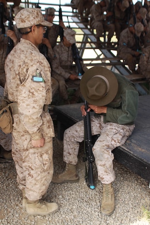 Cpl. Jamison Mersino, Primary Marksmanship Instructor, assists Company M recruits May 15 aboard Edson Range, Weapons and Field Training Battalion, Marine Corps Base Camp Pendelton. During the fifth week of recruit training, PMI's taugh Co. M the basic fundamentals of Marine Corps marksmenship. The PMI's then follow the recruits to firing week to make sure the recruits understand how to properly shoot.