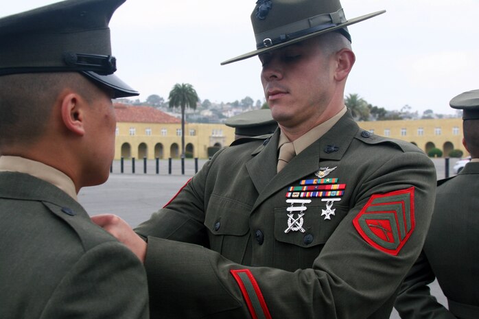 Staff Sgt. Zachary Curran, senior drill instructor, Platoon 2113, Company E, 2nd Recruit Training Battalion, inspects his recruits for the Company Commanders Inspection May 19 aboard Marine Corps Recruit Depot. Curran is on his last cycle on the drill field and will be putting in an officer package in the near future.