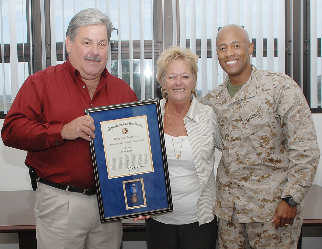 Col. Terry V. Williams, commanding officer, MCLB Albany, poses with Hubert W. Smigelski, Installation and Environment Division   deputy director, MCLB Albany, and his wife, Loraine, after presenting Smigelski with the Meritorious Civilian Service Award, May 4. Smigelski received the award for his outstanding performance of duty while serving as deputy director, I&E Div., from August 2009 - February 2012.