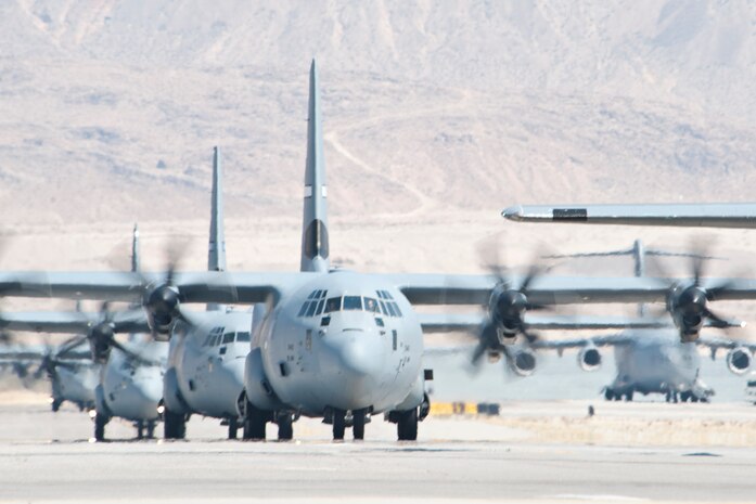 U.S. Air Force C-130 Hercules cargo planes taxi across the active runway at Nellis Air Force Base, Nev., after participating in the Mobility Air Forces Exercise May 23, 2012 over the Nevada Test and Training Range. The U.S. Air Force Weapons School holds MAFEX twice a year to test the ability of C-17 Globemaster III and C-130 Hercules aircrews from Air Force bases around the world to join together in a formation at a specific time and location to insert ground forces and equipment anywhere in the world. (U.S. Air Force photo by Lawrence Crespo)