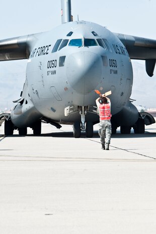 A U.S. Air Force crew chief marshals a C-17 aircraft assigned to the 97th Air Mobility Wing, Altus Air Force Base, Okla., on the Nellis flight line after the crew participated in the Mobility Air Forces Exercise May 23, 2012 over the Nevada Test and Training Range. More than 20 C-17s assembled in aerial formations over the NTTR to conduct air and ground operations as part of the Air Force Weapons School Mobility Air Forces Exercise.  (U.S. Air Force photo by Lawrence Crespo)