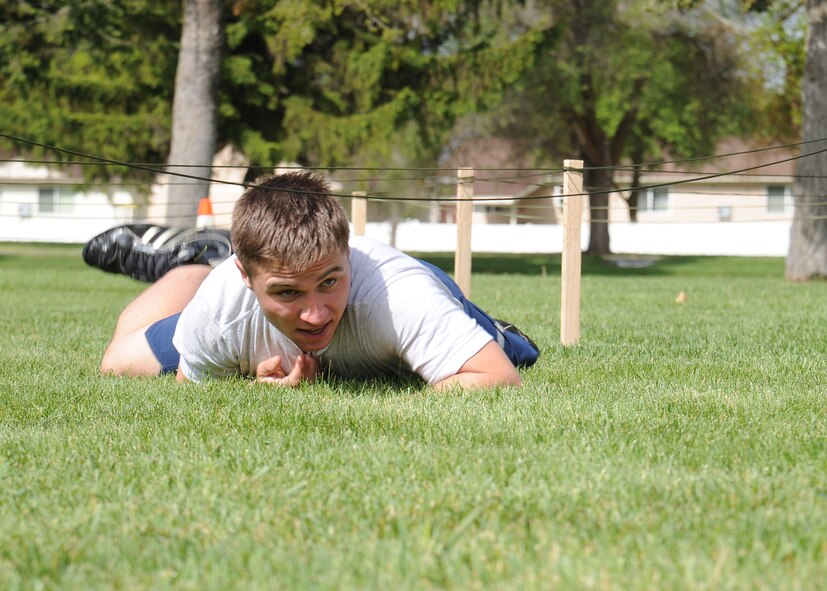 Airman 1st Class Christopher Armitage, 92nd Security Forces Squadron installation patrolman, crawls through an obstacle course during the 101 Critical Days of Summer kickoff event at Fairchild Air Force Base, Wash., May 24, 2012. The Commander’s Cup Challenge featured other events including a 1.6 mile run, Tug-o-War and fire truck pull. (U.S. Air Force photo by Senior Airman Benjamin Stratton/Released)  
