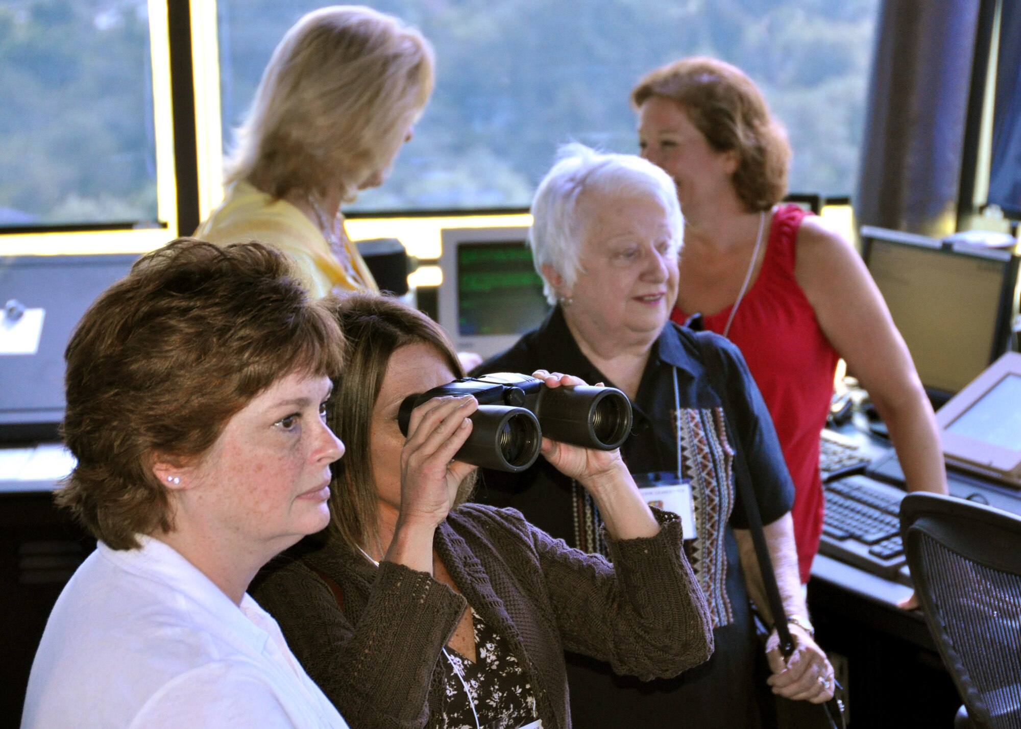 Civic leaders, from left, Michelle Tucker, Stephanie DuPree and Shirley Brown, take turns using binoculars to view airfield operations from the air traffic control tower at MacDill AFB, Fla., recently.  Each year, the 919th Special Operations Wing conducts a civic leader tour to help its community neighbors broaden their perspective of Air Force active duty and Reserve worldwide missions. (U.S. Air Force photo/Tech. Sgt. Jasmin Taylor)