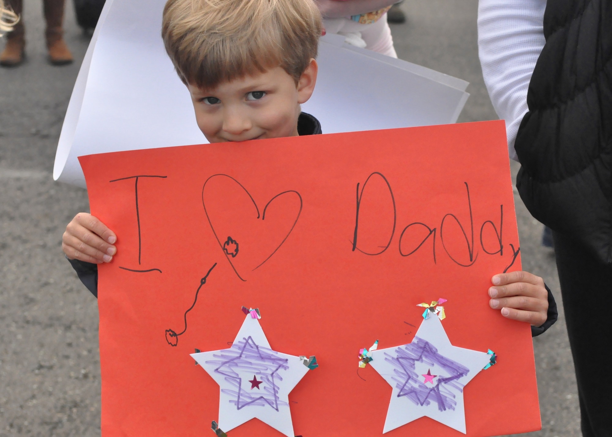 Ethan ZumBrunnen holds a sign while waiting for his father, Lt. Col. Clinton ZumBrunnen, 10th Airlift Squadron commander, to return from a 75-day deployment May 23, 2012, at Joint Base Lewis-McChord, Wash. (U.S. Air Force photo/Senior Airman Leah Young)