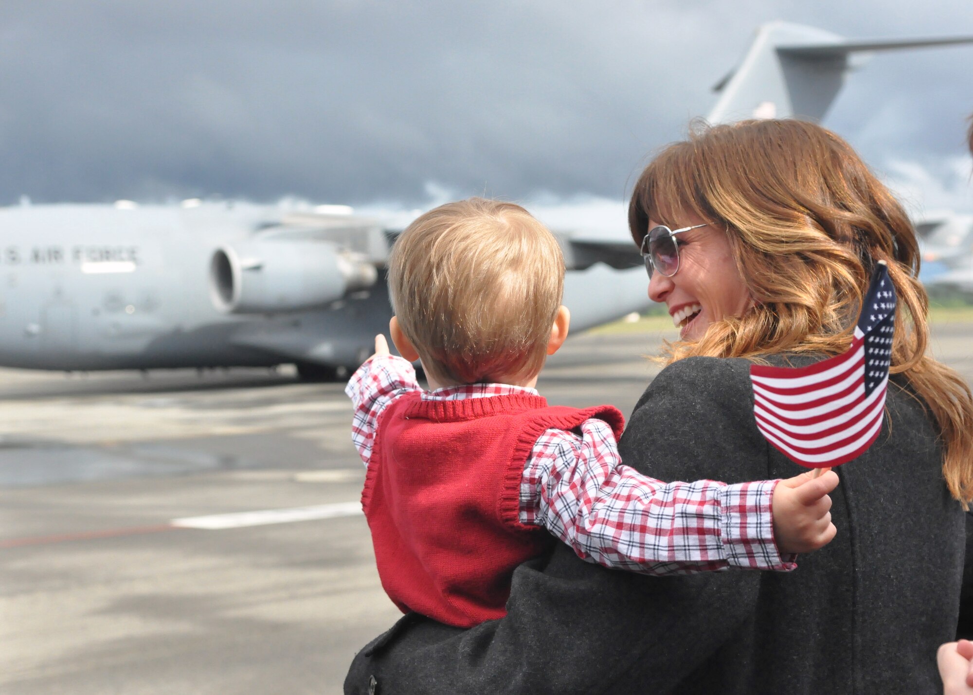 A child waits with his mother as a C-17 Globemaster III taxis down the runway May 23, 2012, at Joint Base Lewis-McChord, Wash. The C-17 brought home more than 90 Airmen from the 10th Airlift Squadron after a 75-day deployment in support of Operations Enduring Freedom and New Dawn. (U.S. Air Force photo/Senior Airman Leah Young)