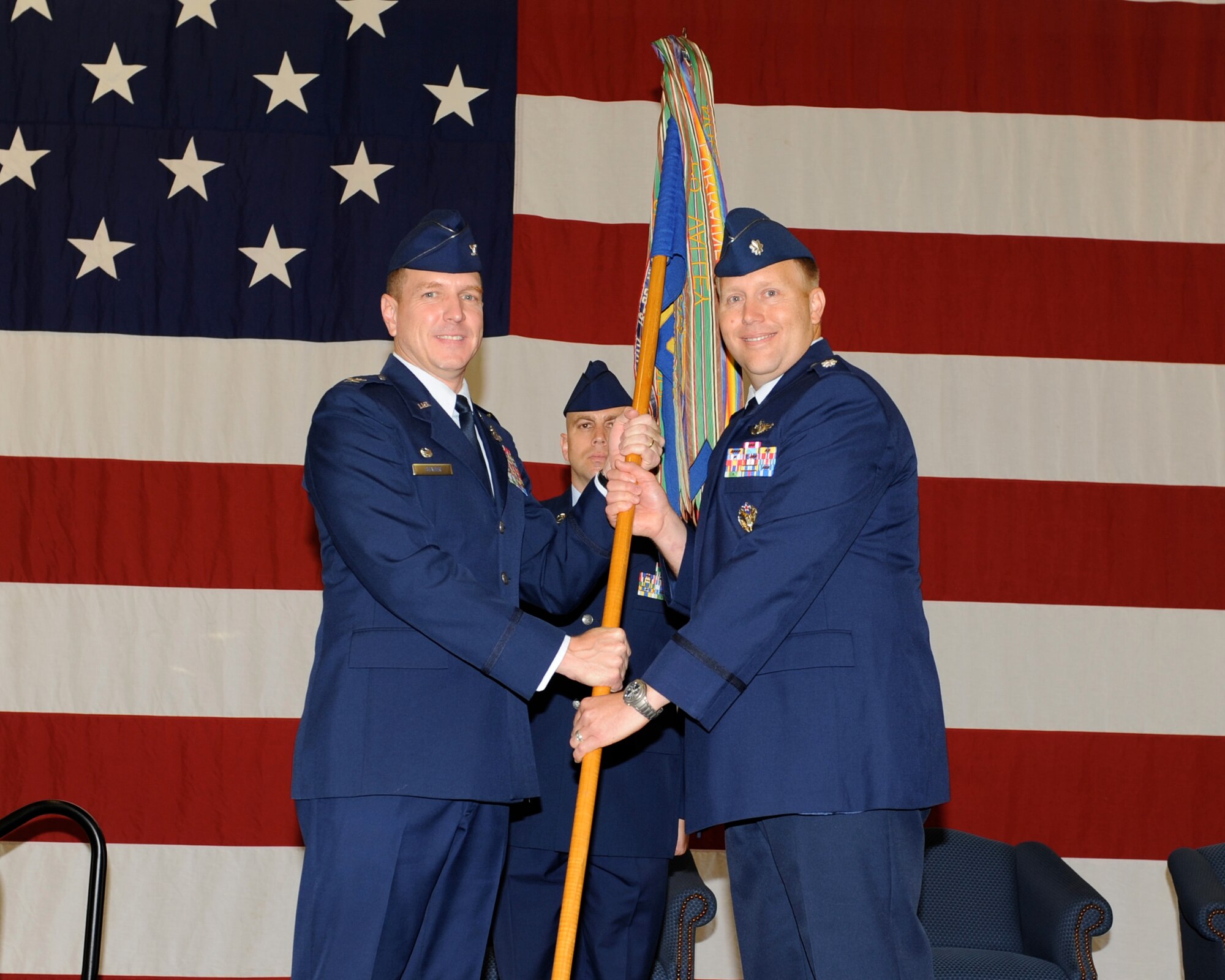 Lt. Col. Brad Hall, 48th Flying Training Squadron commander, receives the 48th FTS guidon from Col. Steve Stater during the change of command ceremony May 17 inside the fuel hangar.  Colonel Hall replaced outgoing commander Lt. Col. Michael O’Connor.  (U.S. Air Force Photo/Elizabeth Owens)
