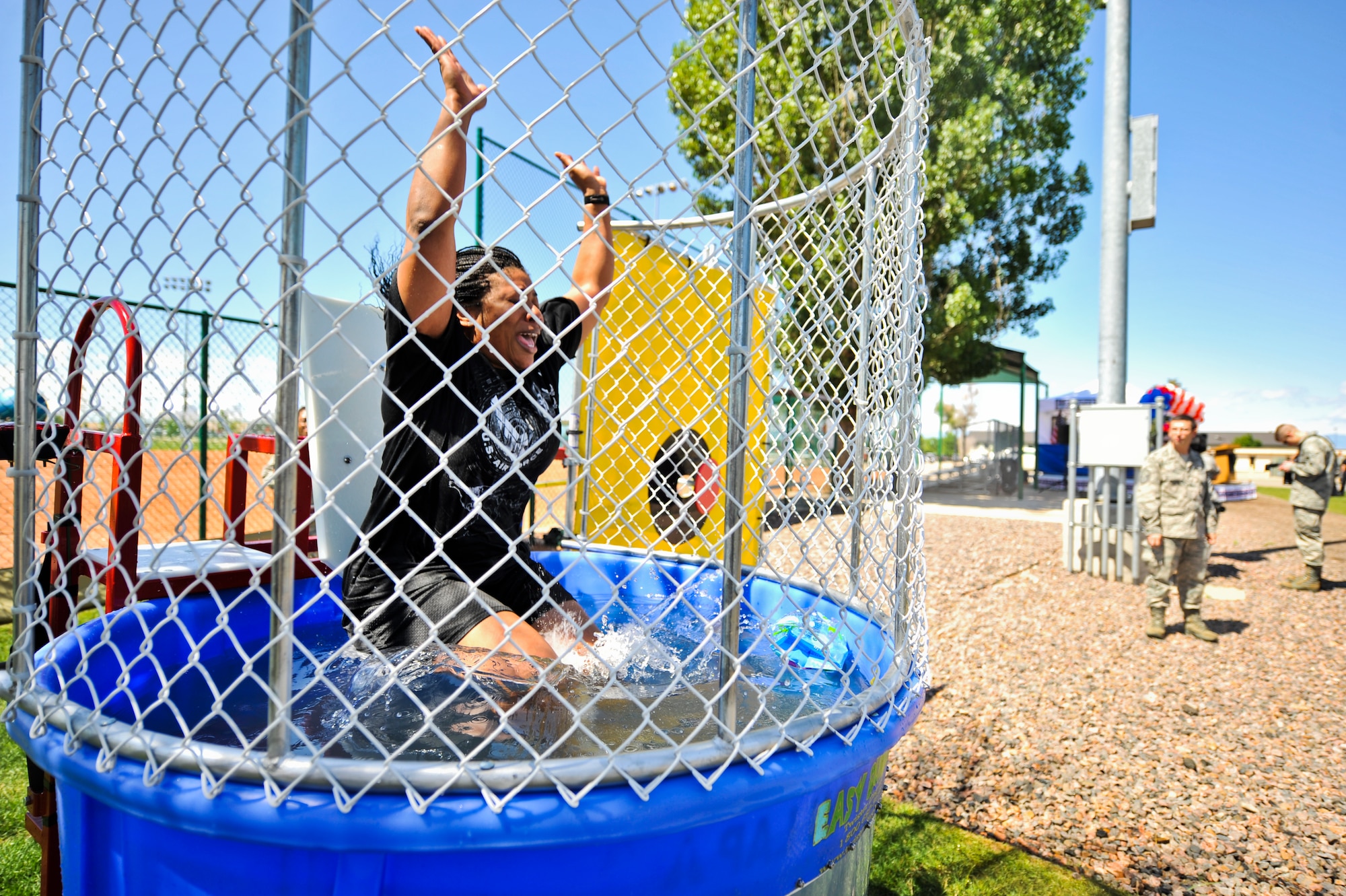 BUCKLEY AIR FORCE BASE, Colo. -- Maj. Halima Muhammad-Whitehead, 460th Force Support Squadron deputy, falls into a dunk tank May 24, 2012. Team Buckley  participated in a day of activities celebrating their excellent rating during a recent Operational Readiness Inspection. (U.S. Air Force Photo/ Senior Airman Paul Labbe)

