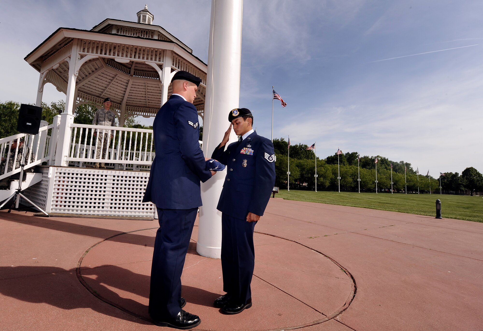 U.S. Air Force Staff Sgt. Ernie Argarin, a 55th Security Forces Squadron member with the National Airborne Operations Center, renders a salute to the U.S. flag at the end of the flag folding ceremony as U.S. Air Force Airman 1st Class Lance Hillenga, 55th SFS, holds it during the 55th SFS retreat held May 17 at Offutt Air Force Base, Neb.  The retreat served as a reminder of all the security forces Airmen who have been lost in the line of duty.  (U.S. Air Force photo by Josh Plueger)