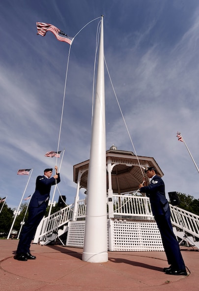 U.S. Air Force Airman 1st Class Lance Hillenga, 55th Security Forces Squadron, and U.S. Air Force Staff Sgt. Ernie Argarin, a 55th SFS member with the National Airborne Operations Center, lower the colors in front of the parade ground's gazebo while performing the flag security detail during the 55th SFS retreat held May 17 at Offutt Air Force Base, Neb.  The retreat was part of Offutt's acknowledgment of the National Police Week.  (U.S. Air Force photo by Josh Plueger)