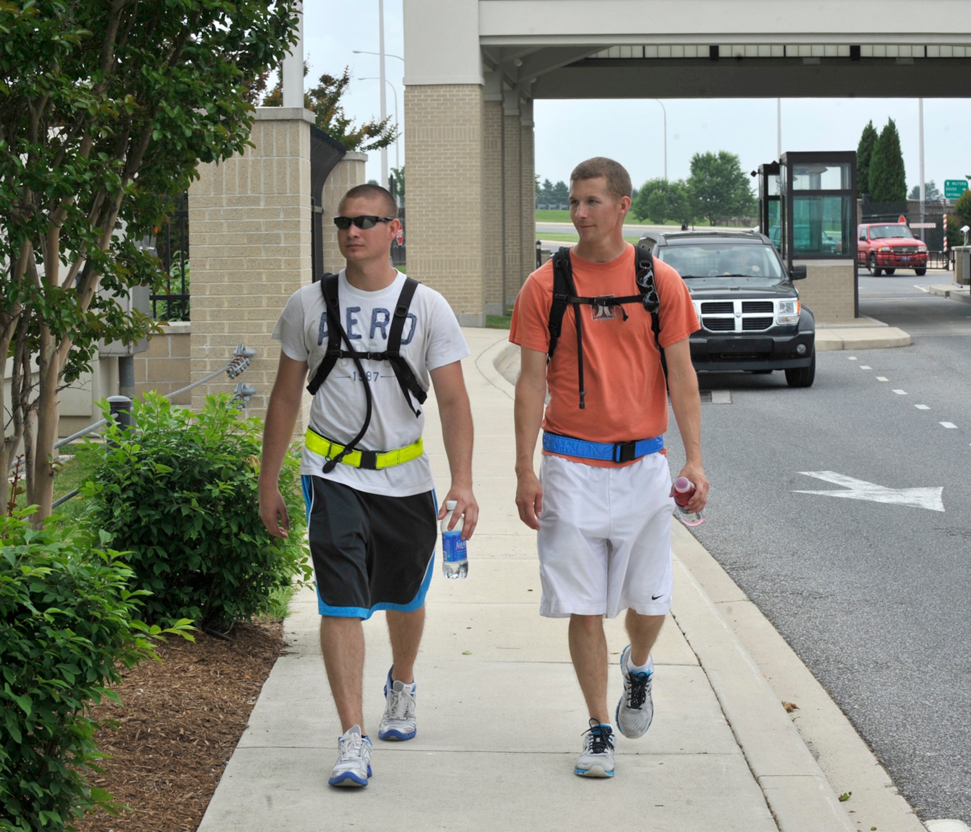 Airman 1st Class Dustin Adkins and Airman 1st Class Sean Melcher walk past the main gate May 24, 2012, on Dover Air Force Base, Del. Adkins and Melcher took part in the Base-2-Base Ruckmarch which went from the Air National Guard Base in New Castle to Dover AFB, a total of 47 miles. (U.S. Air Force photo by Tech. Sgt. Chuck Walker)