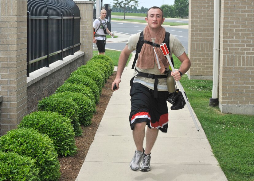 Airman 1st Class Christopher Bobinchak of the 436th Logistics Readiness Squadron runs past the main gate May 24, 2012, on Dover Air Force Base, Del. Bobinchak took part in the Base-2-Base Ruckmarch which went from the Air National Guard base in New Castle to Dover AFB, a total of 47 miles. (U.S. Air Force photo by Tech. Sgt. Chuck Walker)