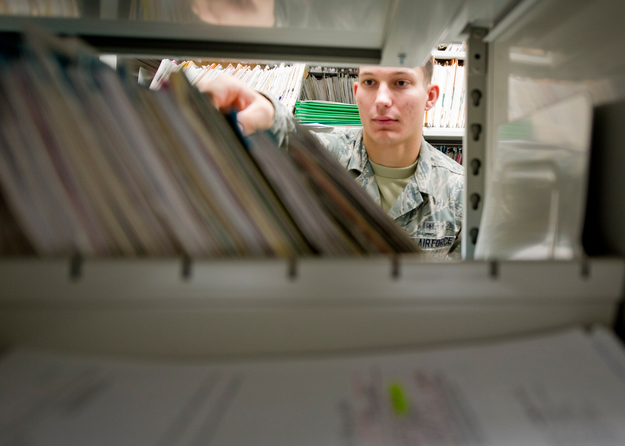 HOLLOMAN AIR FORCE BASE, N.M. – Airman 1st Class Christian Dick, 49th Medical Support Squadron outpatient records technician, searches for a patient’s record May 22. Dick and other outpatient records technicians are responsible for maintaining about 12,000 medical records from Team Holloman’s active duty members and their dependents, civil servants, retirees and their dependents as well. To ensure timely service, all of the records are divided into sections so that the technicians can find any record in a efficient manner. (U.S. Air Force photo by Airman 1st Class Siuta B. Ika/Released)