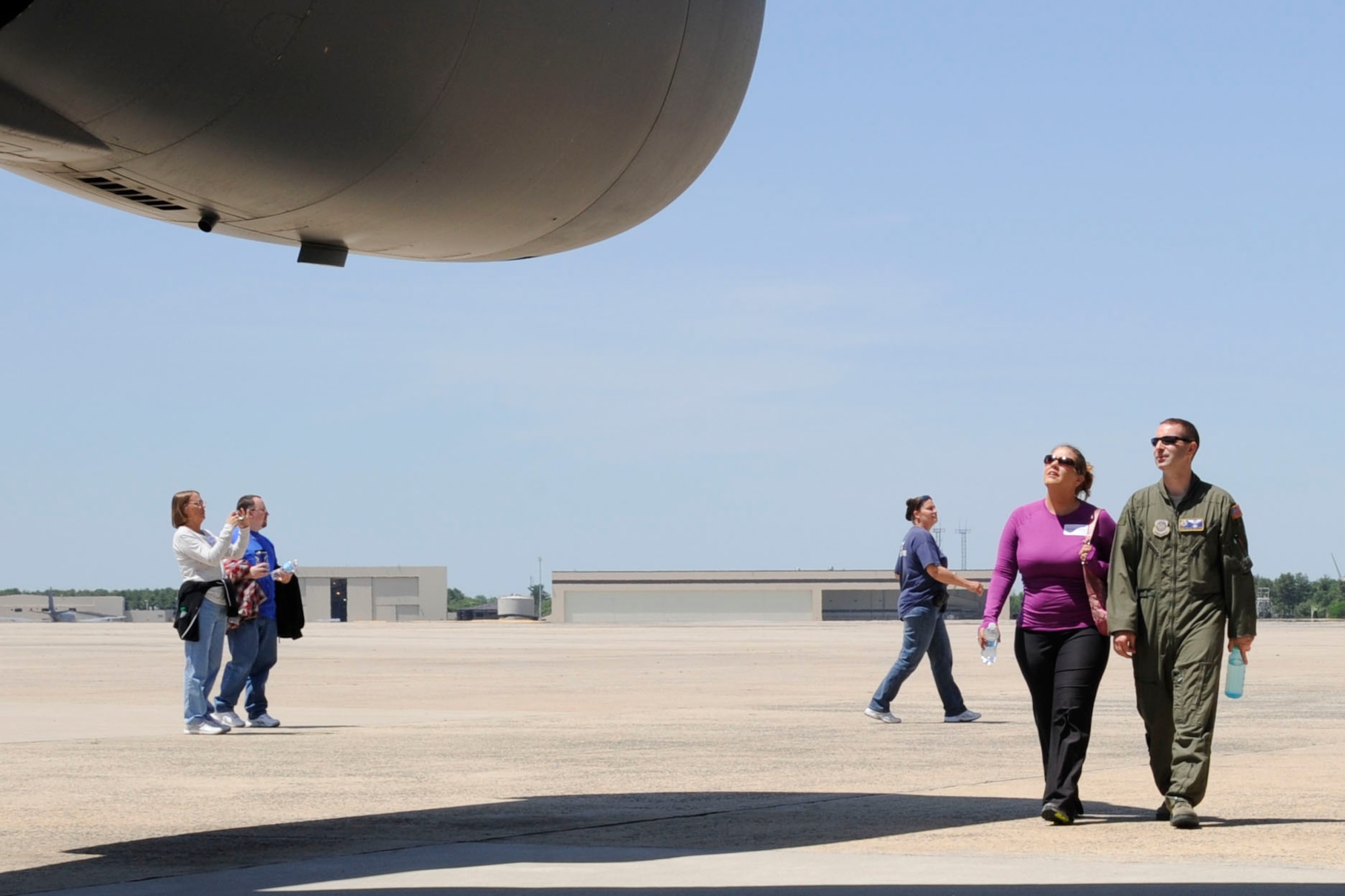 Master Sgt. David Feaster, headquarters test director and C-17a Globemaster III loadmaster with Air Mobility Command test and evaluation squadron, and wife Brenda walk under the wing of the C-17 during the second annual spouse orientation flight here. Spouses got an insider’s look into what their significant others do during the work day. The guests toured the 6th Airlift Squadron facilities, took photos of the aircraft and even got to sit in the cockpit with the pilots. (U.S. Air Force photo by 2nd Lt. Alexis McGee/Released)