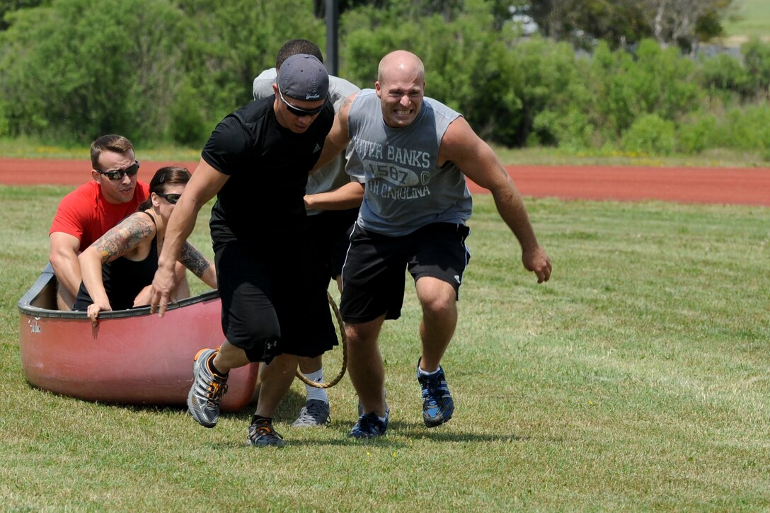 U.S. Air Force Senior Airman Zack Bertsch, right, Air Combat Command Communication Support Squadron system administrator, and Staff Sgt. Jermale Owens, left, ACC NCO in charge MAJCOM command and control center, pull a canoe loaded with teammates during the Squadron Fitness Challenge at the Langley Air Force Base, Va., May 24, 2012. The challenge consisted of several events including a sled pull, tire flip, and obstacle course. (U.S. Air Force photo by Senior Airman Wesley Farnsworth/Released) 