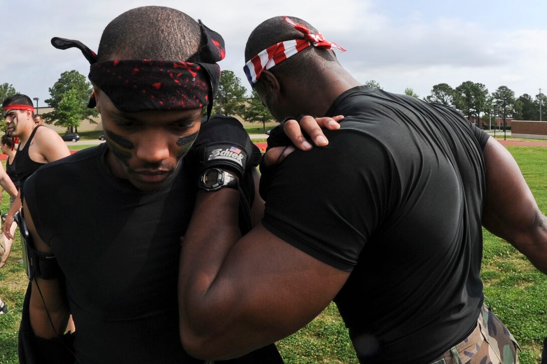 U.S. Air Force Senior Airman Ephraim Colburn, 439th Supply Chain Operations Squadron combat support and sustainment technician, leans on Senior Master Sgt. Ryan Alston, 439th SCOS superintendent, during a stretching exercise prior to the start of the Squadron Fitness Challenge at the Langley Air Force Base, Va., track, May 24, 2012. During the challenge, teams from around the based competed for time in several fitness-based events. (U.S. Air Force photo by Senior Airman Wesley Farnsworth/Released)