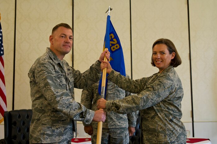 Col. Richard McComb, Joint Base Charleston commander, hands over the squadron guidon to Maj. Laurie-An Lanpher, 628th Comptroller Squadron incoming commander, during the 628th CPTS Change of Command ceremony at JB Charleston - Air Base, S.C., May 23, 2012. The handing over of the guidon symbolizes the changing of a command. (U.S. Air Force photo/Airman 1st Class George Goslin)