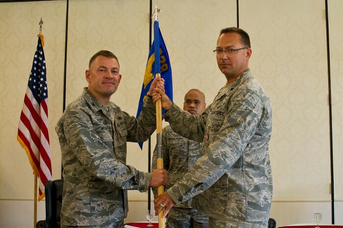 Col. Richard McComb, Joint Base Charleston commander, takes the squadron guidon from Lt. Col. Trevor Whitehill, 628th Comptroller Squadron outgoing commander, during the 628th CPTS Change of Command ceremony at JB Charleston - Air Base, S.C., May 23, 2012. The handing over of the guidon symbolizes the changing of a command. (U.S. Air Force photo/Airman 1st Class George Goslin)
