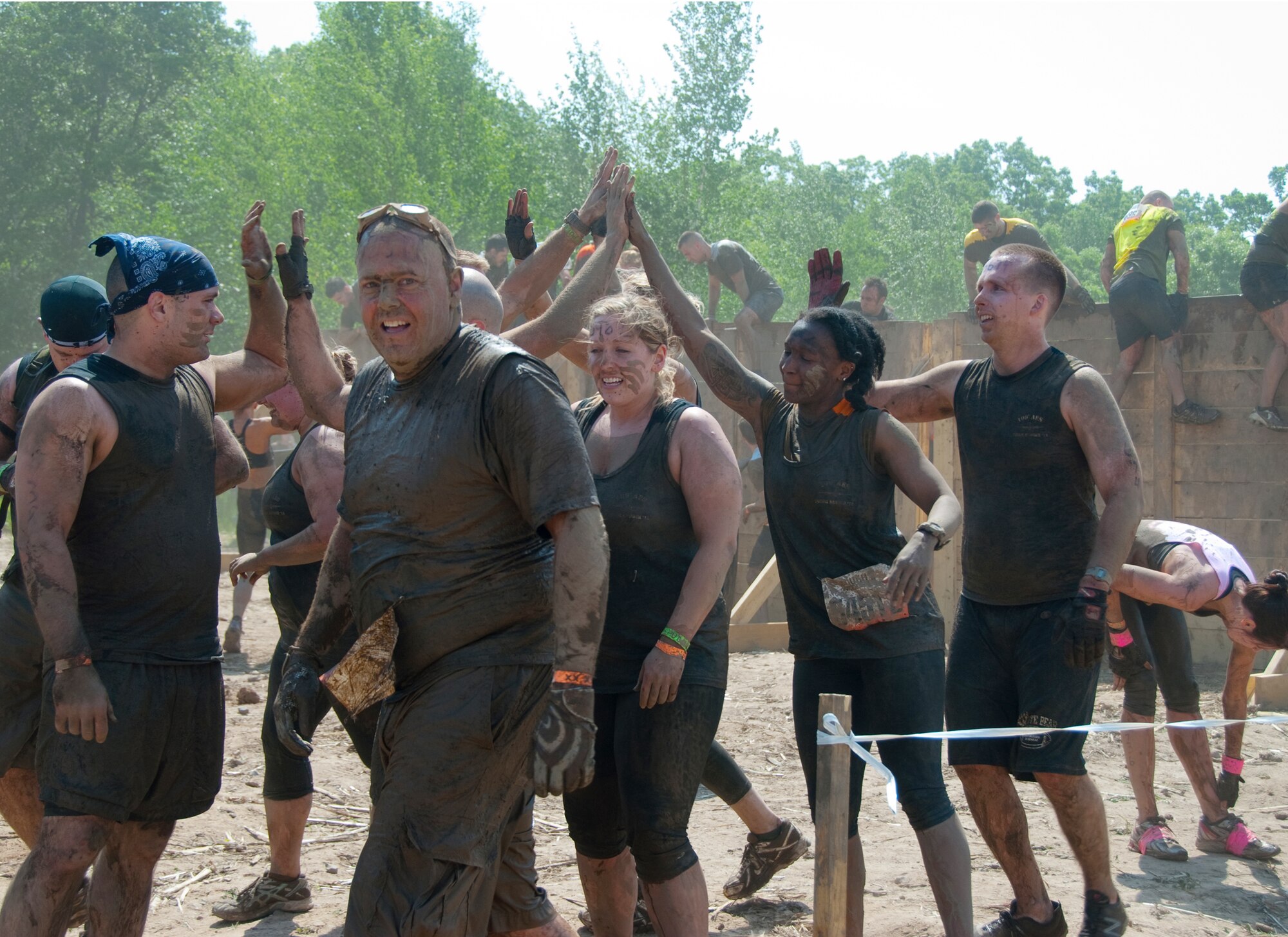 Members of the 109th Aeromedical Evacuation Squadron, Minnesota Air National Guard team celebrate getting over a tough obstacle at the Tough Mudder in Somerset, Wis. on May 19, 2012.  About a dozen Aeromeds made up one team and there were at least a dozen others from the 133rd Airlift Wing getting muddy for exercise, camaraderie, and to help raise money for the Wounded Warrior project.  U.S. Air Force Photo by Staff Sgt. Jonathan Young